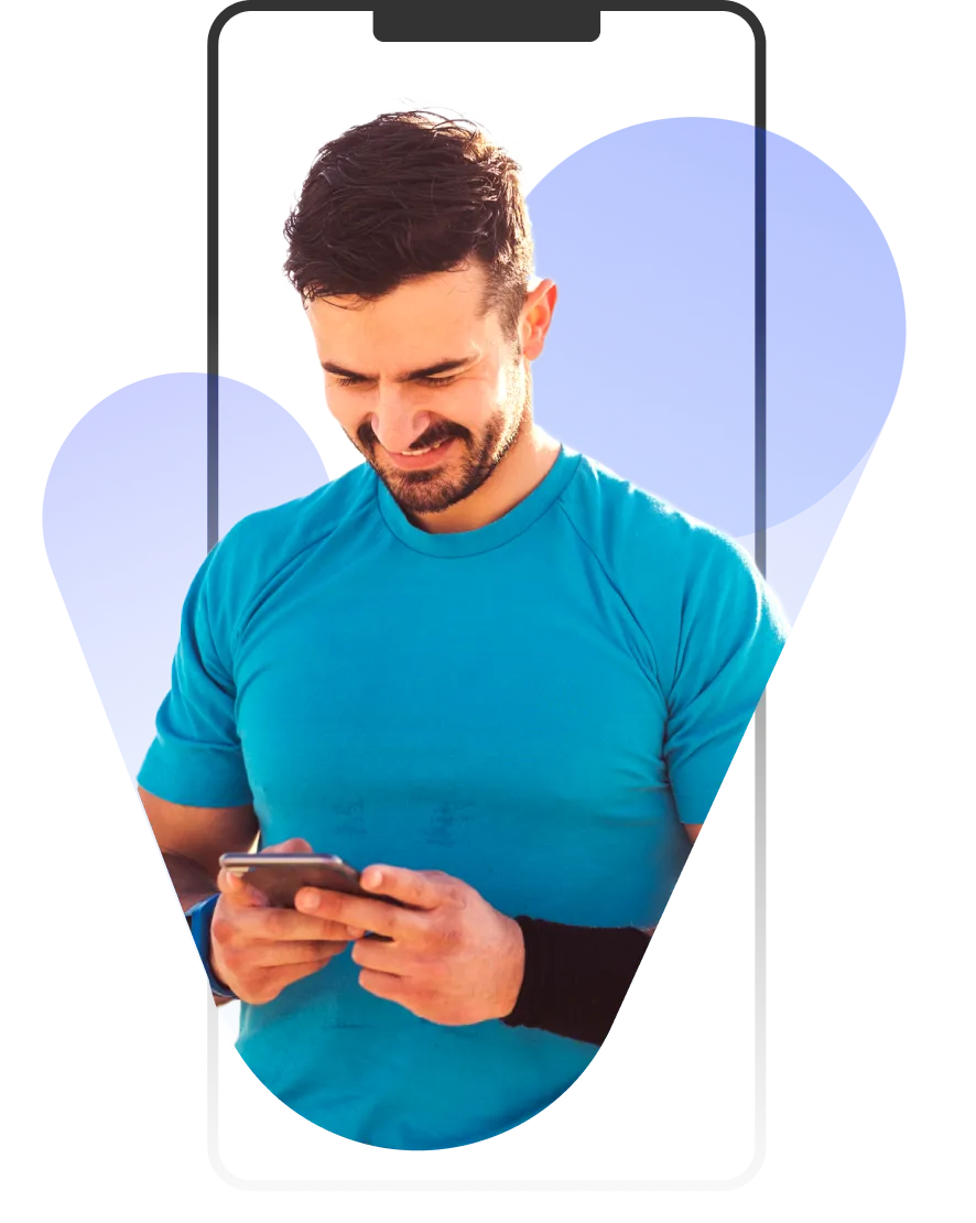 A man in a blue shirt looking at his cell phone.